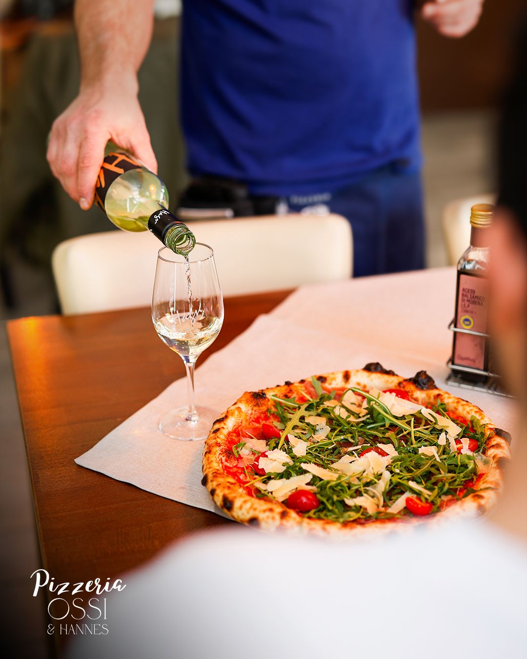 Pizza Rucola serviert mit Weißwein — Pizzeria Ossi