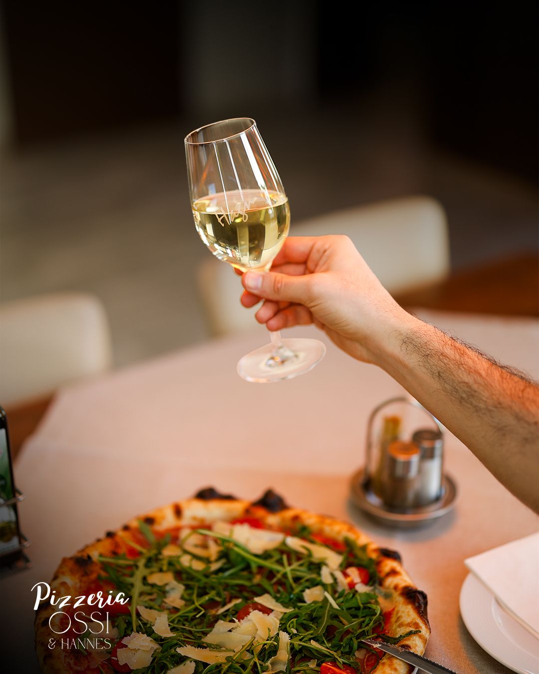 Weißwein-Cheers über Pizza — Pizzeria Ossi Atmosphäre